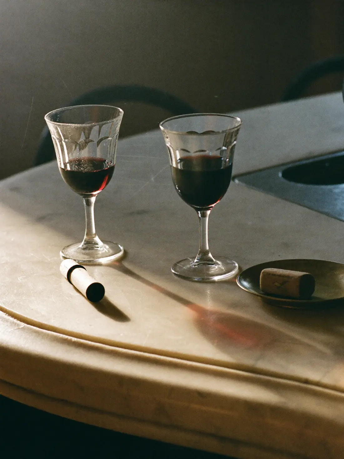 Due ombre di vino rosso sul marmo, accanto al gesso della lavagna